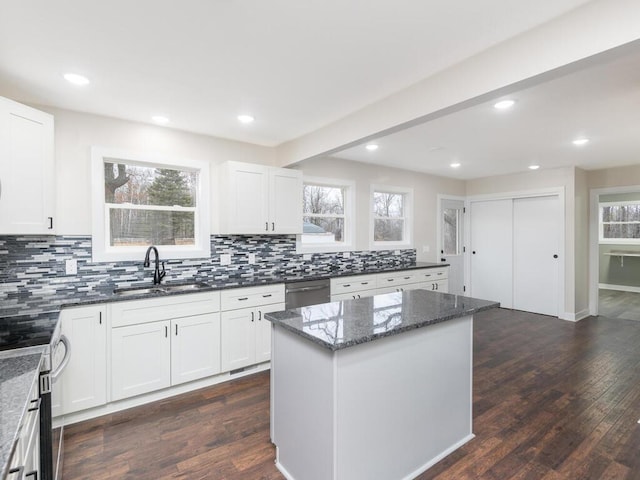 kitchen with a center island, sink, decorative backsplash, dark hardwood / wood-style flooring, and stainless steel appliances