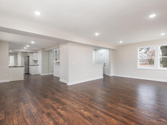 unfurnished living room with dark wood-type flooring