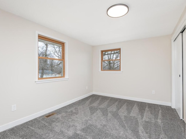 unfurnished bedroom featuring carpet floors and multiple windows