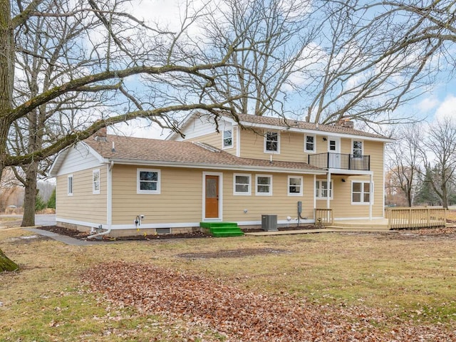 rear view of property featuring a lawn, cooling unit, a balcony, and a deck