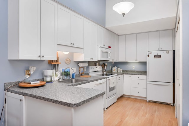 kitchen with white appliances, sink, decorative light fixtures, light hardwood / wood-style flooring, and white cabinetry