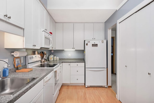 kitchen with white appliances, light hardwood / wood-style flooring, white cabinetry, and sink