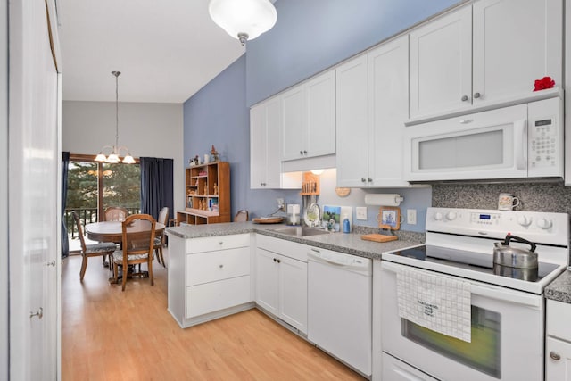 kitchen featuring white appliances, an inviting chandelier, white cabinets, hanging light fixtures, and light hardwood / wood-style flooring