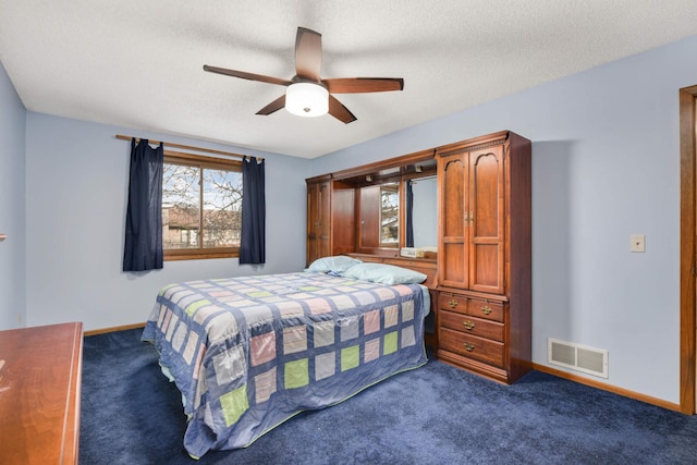 carpeted bedroom featuring ceiling fan and a textured ceiling