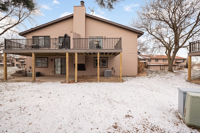 snow covered property with a wooden deck and cooling unit