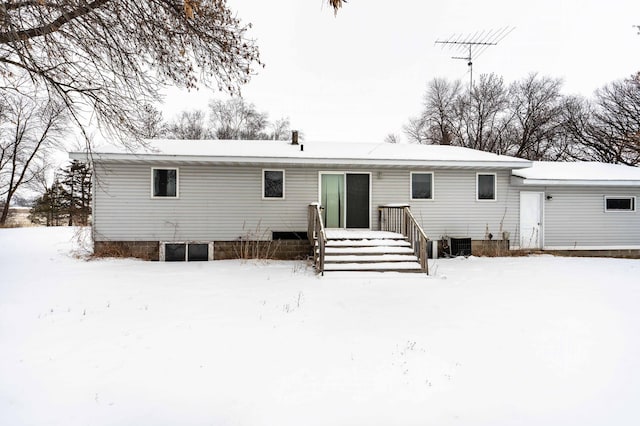 snow covered rear of property with central AC