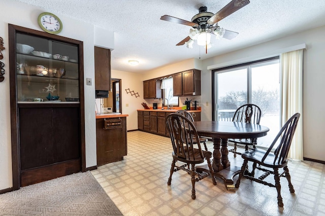 dining room with a textured ceiling, ceiling fan, and sink