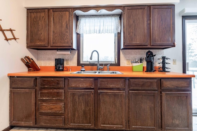 kitchen featuring dark brown cabinetry, tasteful backsplash, and sink