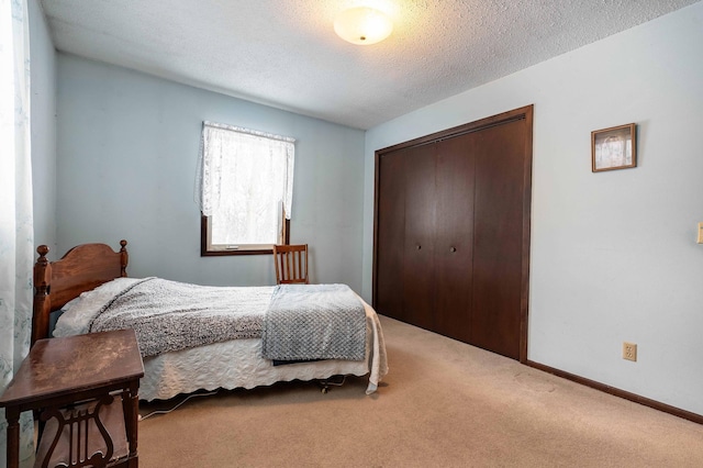 carpeted bedroom featuring a closet and a textured ceiling