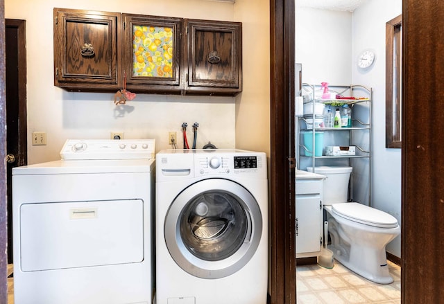 laundry room featuring washer and clothes dryer and cabinets