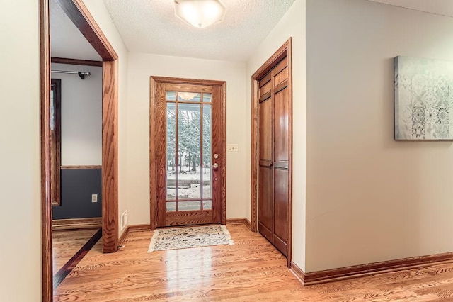 entryway featuring a textured ceiling and light hardwood / wood-style floors