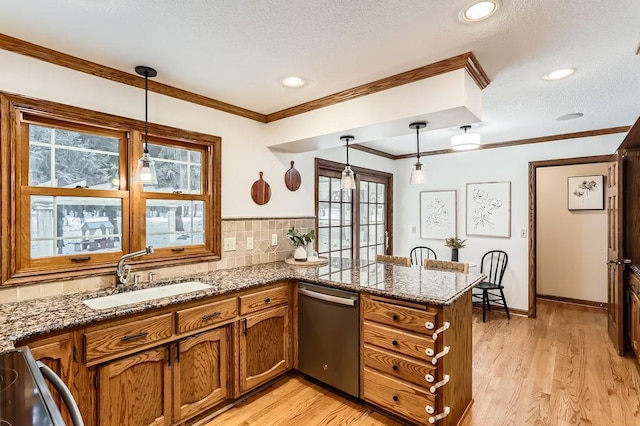 kitchen featuring pendant lighting, sink, stainless steel dishwasher, and kitchen peninsula