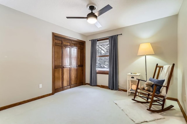 sitting room featuring light colored carpet and ceiling fan