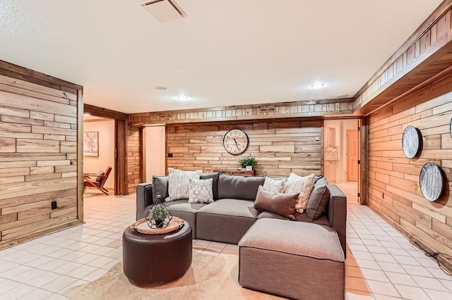 living room featuring light tile patterned floors and wood walls