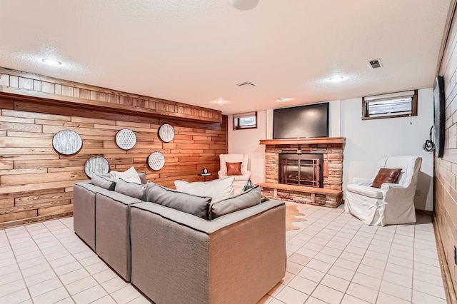 tiled living room featuring a fireplace and wooden walls