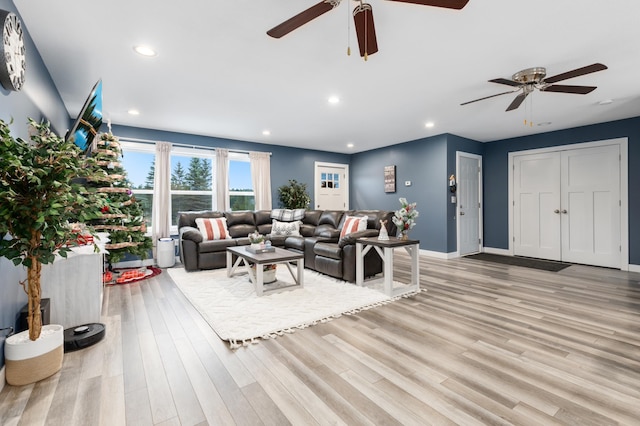 living room with ceiling fan and light hardwood / wood-style flooring