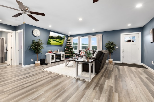 living room featuring ceiling fan and light wood-type flooring