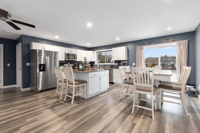 kitchen featuring white cabinetry, a breakfast bar, appliances with stainless steel finishes, and a center island