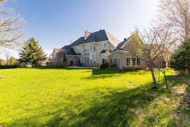 rear view of property featuring a lawn