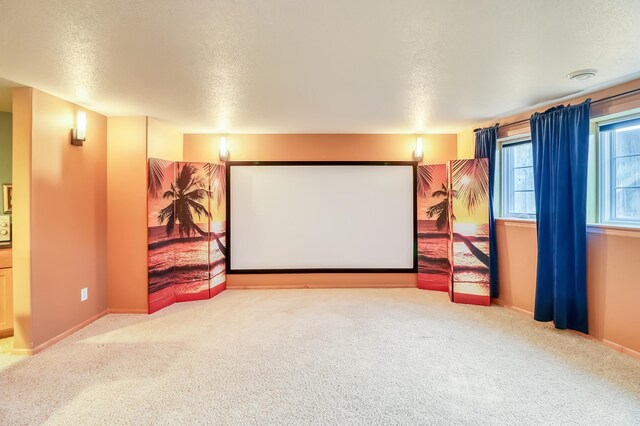 carpeted cinema room featuring a textured ceiling