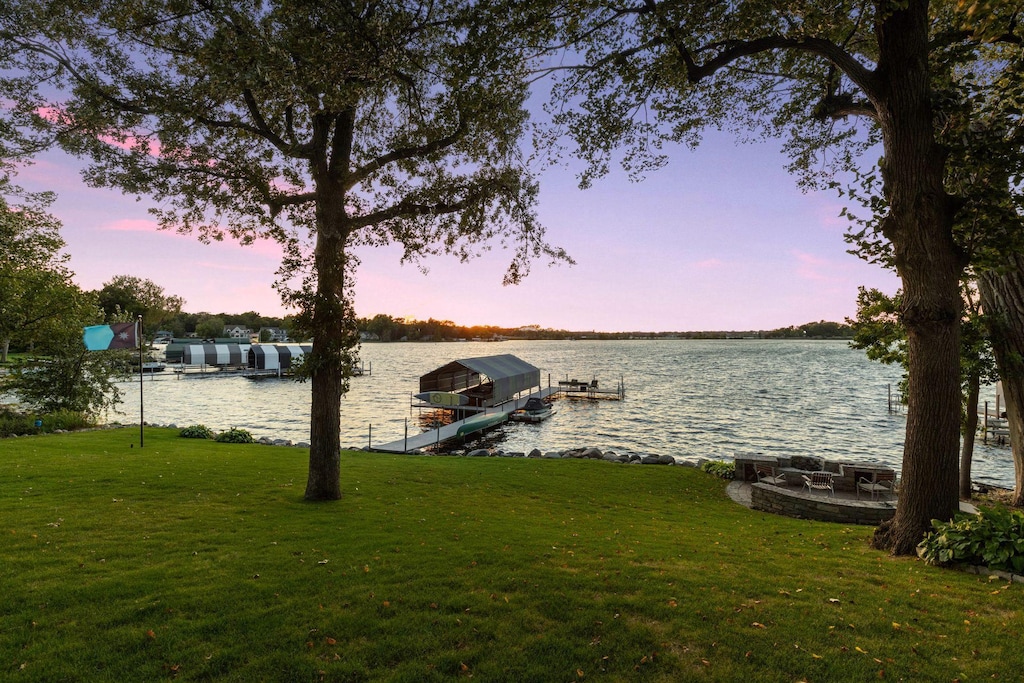 view of dock featuring a water view and a lawn