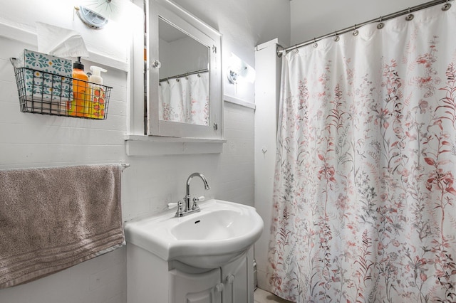 bathroom featuring a shower with shower curtain and sink