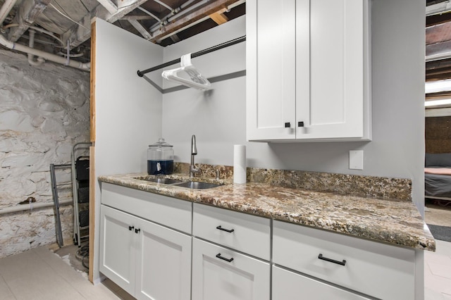 kitchen with sink, white cabinets, and dark stone counters