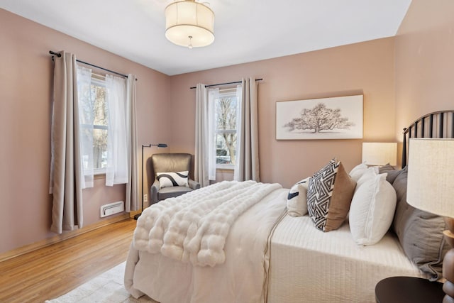 bedroom with multiple windows and light wood-type flooring