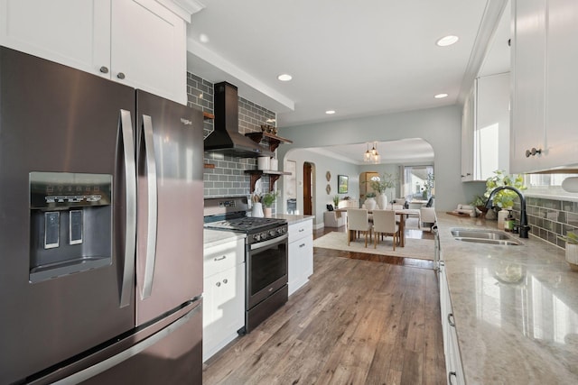 kitchen featuring white cabinets, ventilation hood, appliances with stainless steel finishes, and sink