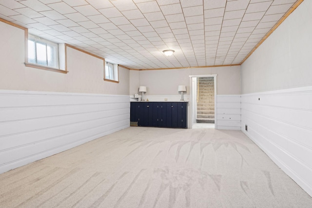 basement with carpet floors and ornamental molding