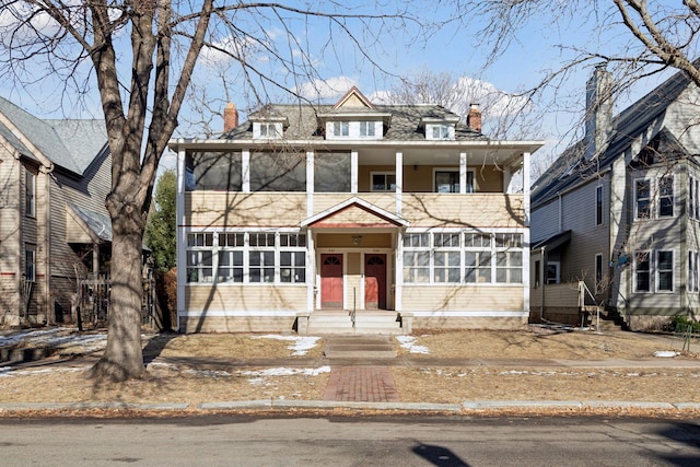 view of front facade with a balcony and a sunroom