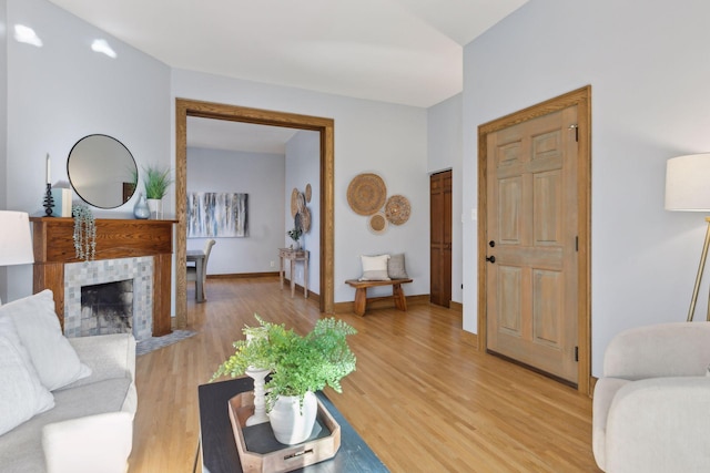 living room with light hardwood / wood-style flooring and a tile fireplace