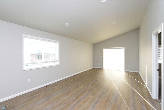 unfurnished room with light wood-type flooring and vaulted ceiling