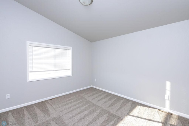 unfurnished room with carpet flooring and lofted ceiling