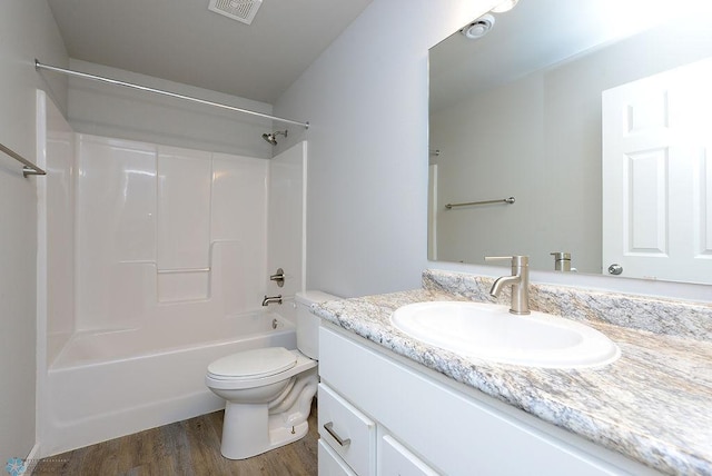 full bathroom with bathing tub / shower combination, vanity, hardwood / wood-style flooring, and toilet