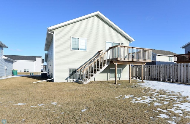 back of property with a lawn and a deck