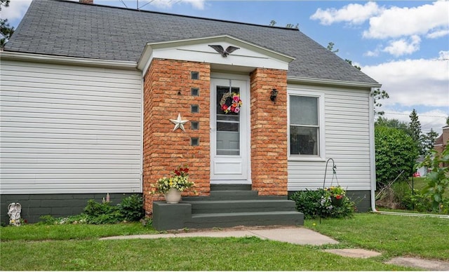 view of exterior entry with a yard