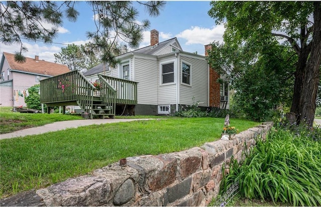 exterior space featuring a deck and a lawn