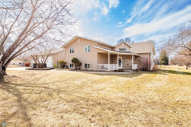 traditional-style house featuring a porch, an attached garage, and a front lawn