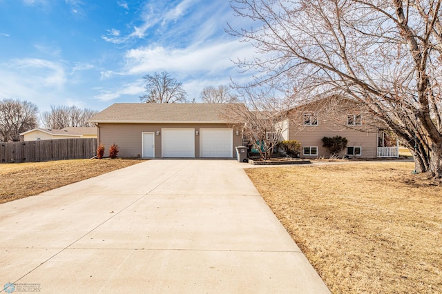 view of front of house with driveway, an attached garage, a front lawn, and fence