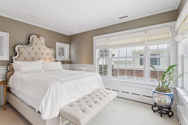 carpeted bedroom with crown molding and a baseboard heating unit