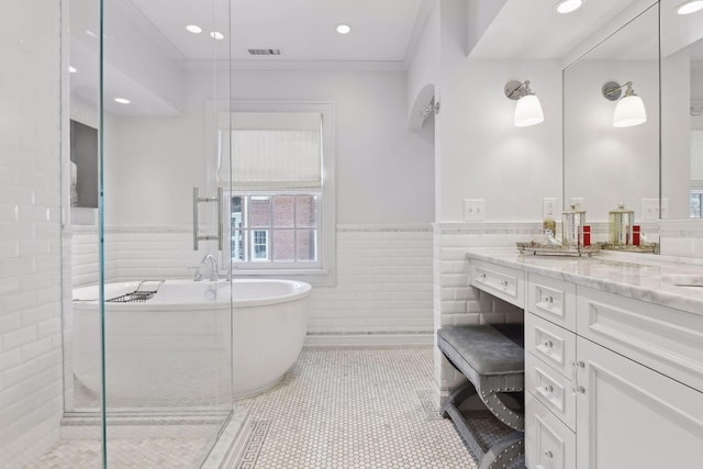 bathroom featuring crown molding, tile walls, vanity, plus walk in shower, and tile patterned floors