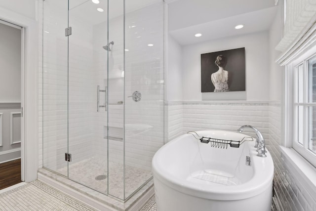 bathroom featuring tile walls, tile patterned floors, and shower with separate bathtub