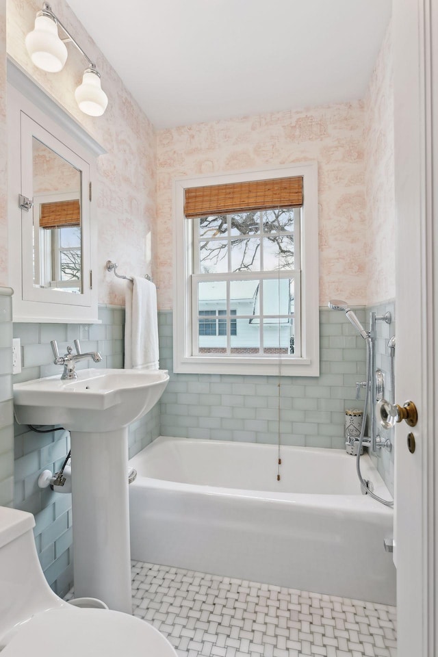 bathroom featuring a washtub and toilet