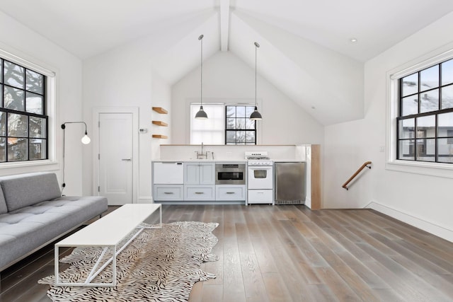 unfurnished living room with sink, hardwood / wood-style flooring, and lofted ceiling with beams