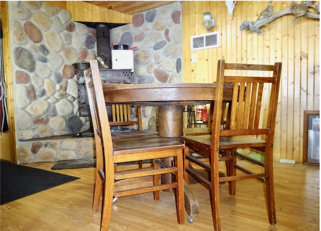 dining room featuring wood-type flooring and wooden walls