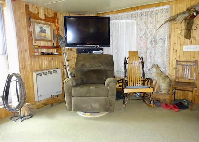 sitting room featuring wood walls, carpet floors, and heating unit