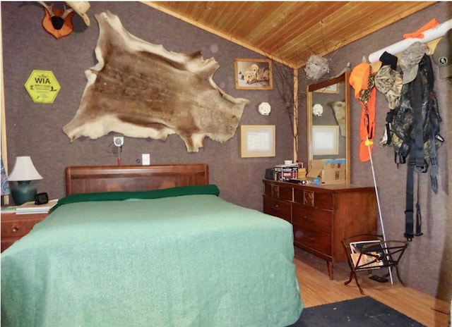 bedroom with vaulted ceiling, wood-type flooring, and wooden ceiling