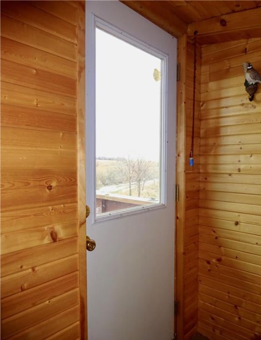 entryway with wood walls and wooden ceiling