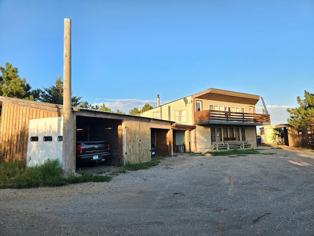 view of front of home featuring dirt driveway, an outbuilding, and a garage